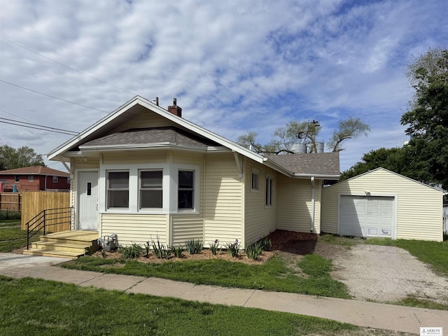 4227 N 57th St, Lincoln, NE 68507 - view of front of house featuring dirt driveway, an outdoor structure, roof with shingles, and a garage