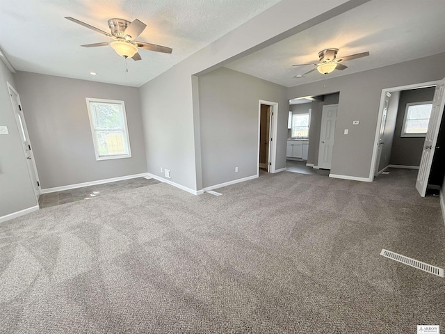 4227 N 57th St, Lincoln, NE 68507 - spare room featuring a ceiling fan, baseboards, plenty of natural light, and carpet floors