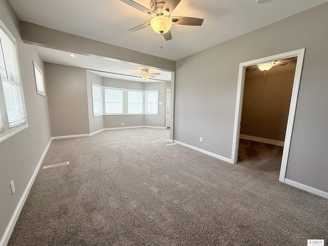 4227 N 57th St, Lincoln, NE 68507 - unfurnished bedroom featuring carpet flooring, baseboards, a ceiling fan, and a walk in closet
