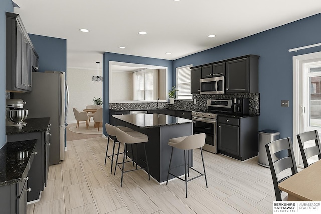 9002 N 156th Ave, Bennington, NE 68007 - kitchen with appliances with stainless steel finishes, a kitchen bar, tasteful backsplash, healthy amount of natural light, and recessed lighting
