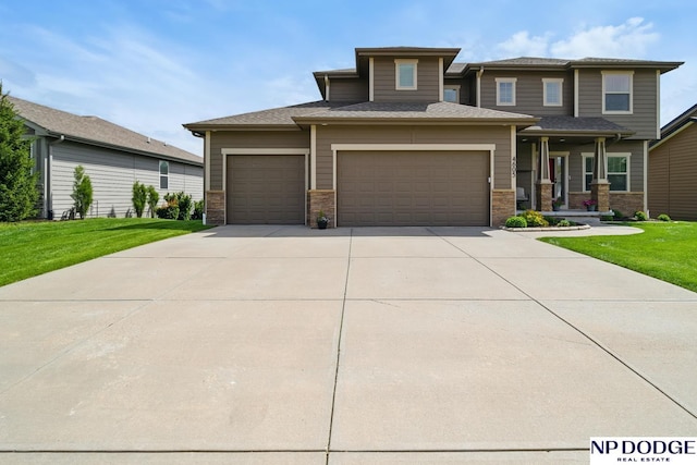 prairie-style house with a garage, driveway, and a front lawn