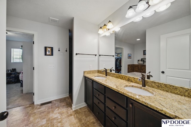 full bath with baseboards and double vanity