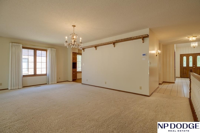6630 Flint Ridge Rd, Lincoln, NE 68506 - spare room featuring a chandelier, light colored carpet, baseboards, and a textured ceiling