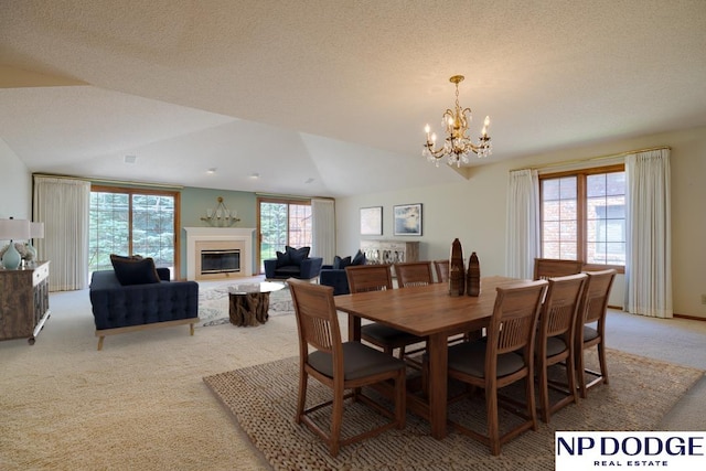 6630 Flint Ridge Rd, Lincoln, NE 68506 - dining space with light colored carpet, a chandelier, vaulted ceiling, and a glass covered fireplace