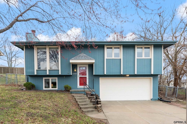 bi-level home featuring a garage and concrete driveway