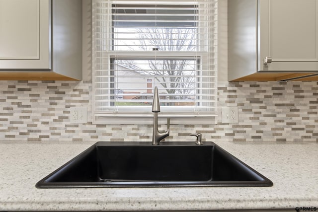 kitchen view of a sink and decorative backsplash
