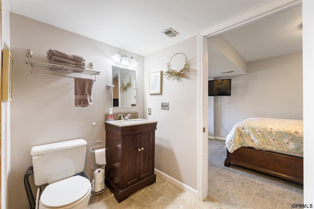 ensuite bathroom featuring toilet, baseboards, and vanity