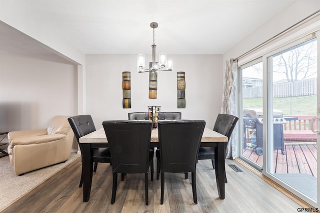 dining space with a chandelier and wood finished floors
