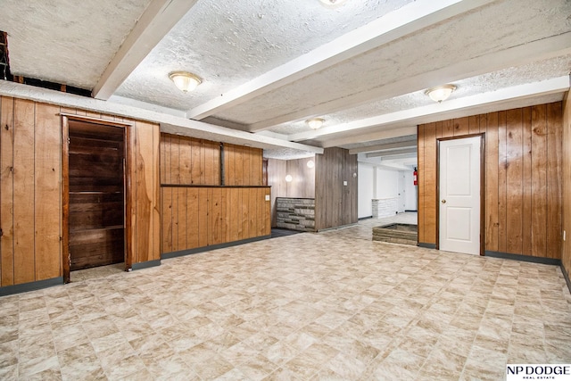 finished basement with wood walls, light flooring, and baseboards