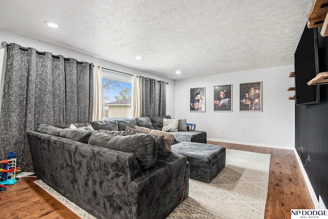 living room featuring wood finished floors, recessed lighting, a textured ceiling, and baseboards