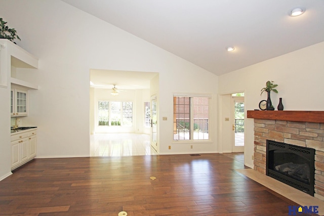 6427 Lone Tree Dr, Lincoln, NE 68512 - unfurnished living room with a stone fireplace, high vaulted ceiling, dark wood-style floors, baseboards, and recessed lighting