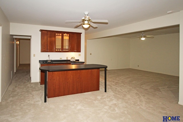 6427 Lone Tree Dr, Lincoln, NE 68512 - kitchen featuring light carpet, dark countertops, a breakfast bar, ceiling fan, and a center island