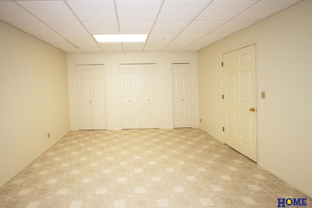 6427 Lone Tree Dr, Lincoln, NE 68512 - unfurnished bedroom with two closets, a drop ceiling, and light carpet