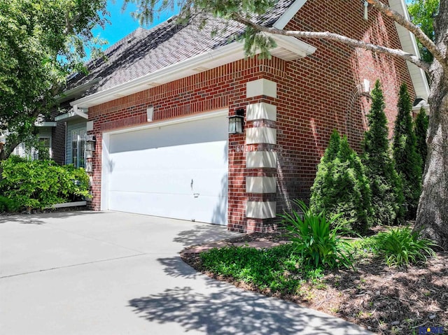 6427 Lone Tree Dr, Lincoln, NE 68512 - view of home's exterior with brick siding, driveway, a garage, and a shingled roof