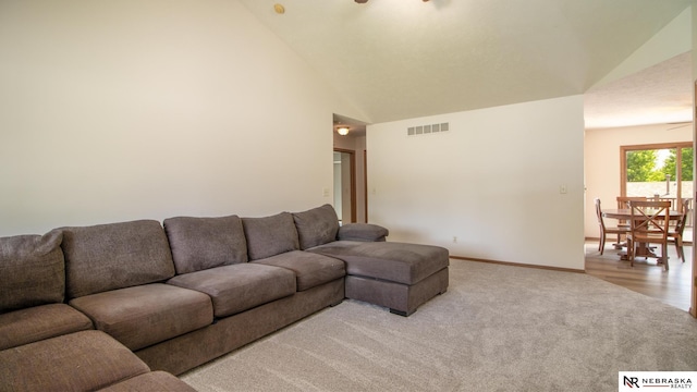 719 Cory Dr, Seward, NE 68434 - living area with light colored carpet, baseboards, and high vaulted ceiling