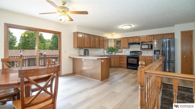 719 Cory Dr, Seward, NE 68434 - kitchen with black appliances, a peninsula, light countertops, a ceiling fan, and brown cabinetry