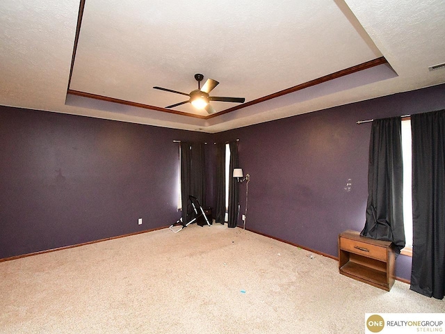 unfurnished room with a raised ceiling, baseboards, and a textured ceiling