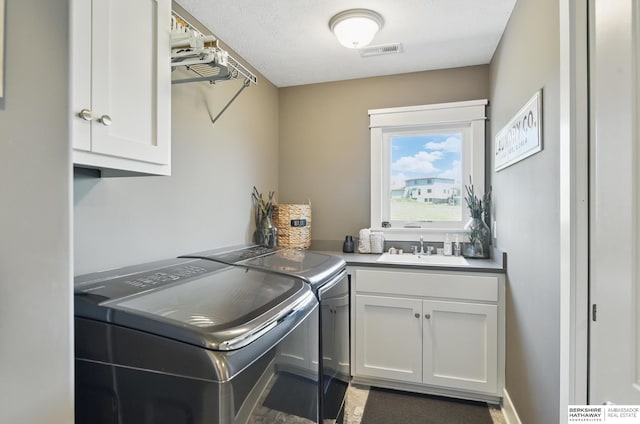 laundry room with independent washer and dryer and cabinet space