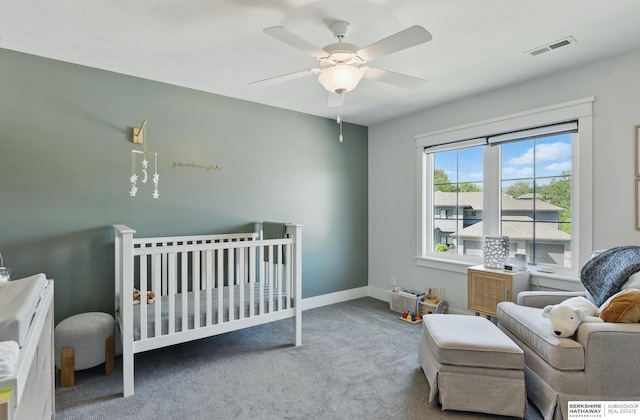 bedroom featuring carpet flooring, baseboards, a ceiling fan, and a crib