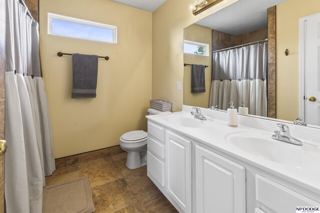 18667 R St, Omaha, NE 68135 - full bath featuring toilet, double vanity, stone finish flooring, and a shower with curtain