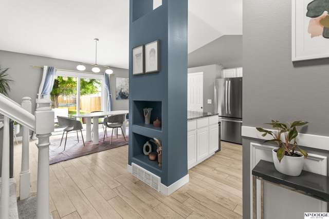 18667 R St, Omaha, NE 68135 - kitchen featuring freestanding refrigerator, white cabinetry, light wood-style floors, and vaulted ceiling