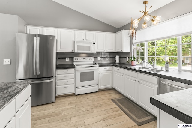 18667 R St, Omaha, NE 68135 - kitchen featuring appliances with stainless steel finishes, a sink, vaulted ceiling, a chandelier, and light wood-type flooring