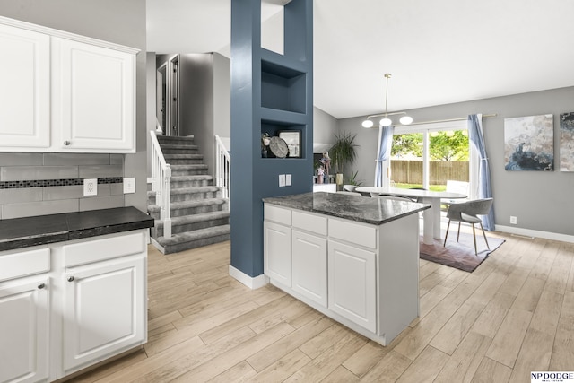18667 R St, Omaha, NE 68135 - kitchen featuring light wood-style floors, white cabinetry, baseboards, decorative light fixtures, and vaulted ceiling