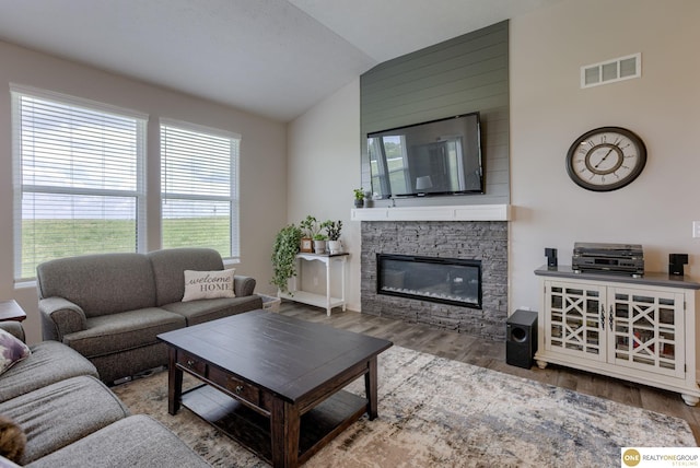12618 Glenn St, Omaha, NE 68138 - living room featuring lofted ceiling, wood finished floors, and a stone fireplace