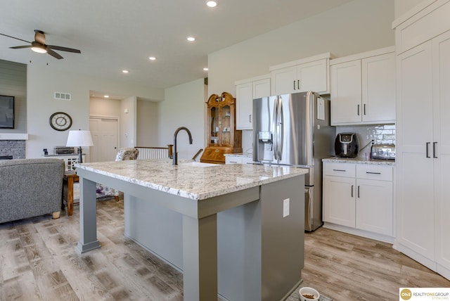 12618 Glenn St, Omaha, NE 68138 - kitchen with stainless steel refrigerator with ice dispenser, open floor plan, a ceiling fan, light wood-style flooring, and white cabinetry