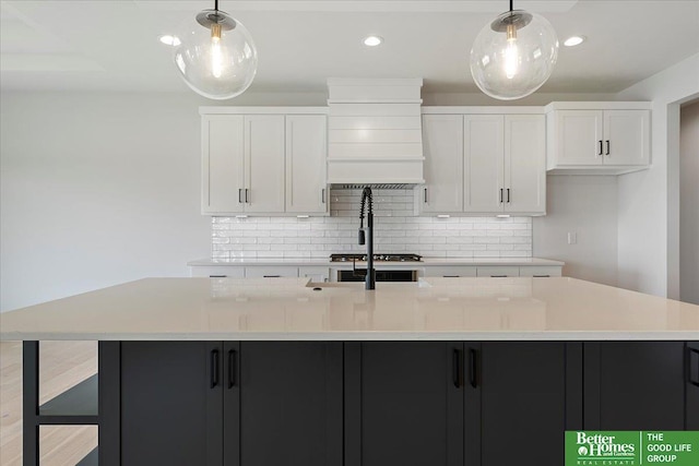 kitchen featuring decorative backsplash, a spacious island, light countertops, white cabinets, and recessed lighting