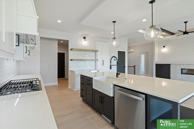 kitchen with stainless steel appliances, a sink, tasteful backsplash, light countertops, and recessed lighting
