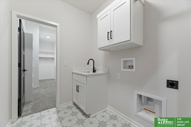 laundry area featuring electric dryer hookup, washer hookup, cabinet space, light flooring, and baseboards