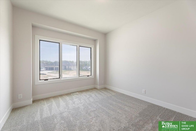 spare room featuring baseboards and carpet floors