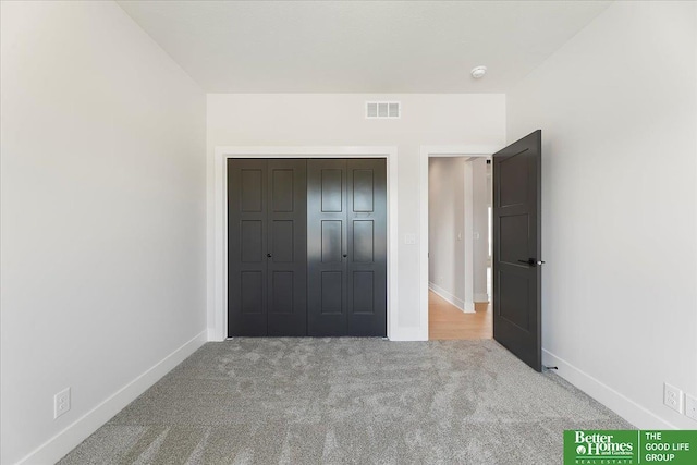 unfurnished bedroom featuring carpet flooring, baseboards, and a closet