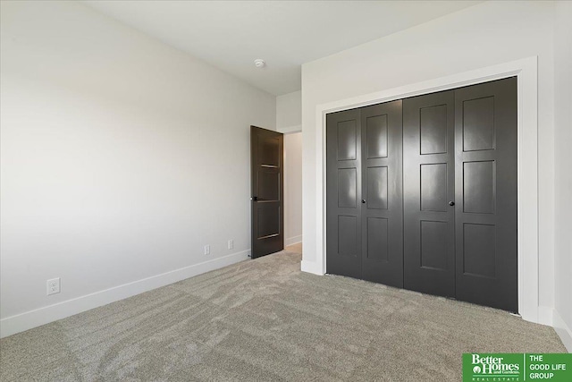 unfurnished bedroom with carpet, baseboards, and a closet