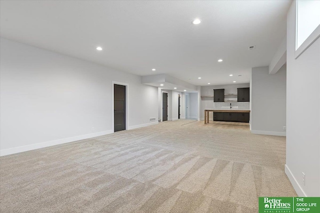 unfurnished living room featuring recessed lighting, light carpet, and baseboards