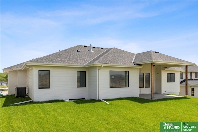 back of house featuring a shingled roof, a yard, cooling unit, and a patio area