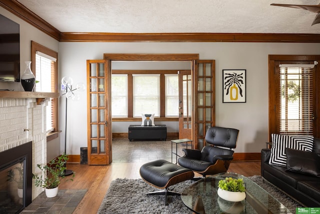 319 N 37th St, Omaha, NE 68131 - living area featuring french doors, crown molding, a brick fireplace, a textured ceiling, and baseboards