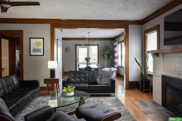 319 N 37th St, Omaha, NE 68131 - living room featuring ornamental molding, wood finished floors, healthy amount of natural light, a brick fireplace, and baseboards