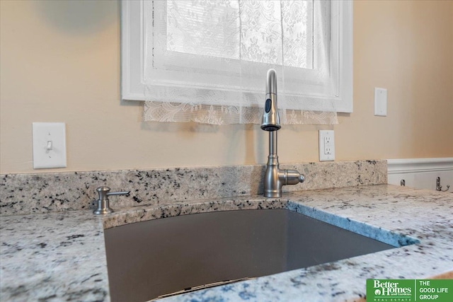 kitchen view of a sink and light stone countertops