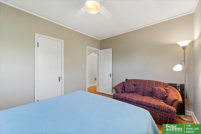 bedroom with crown molding, wood finished floors, ceiling fan, and baseboards