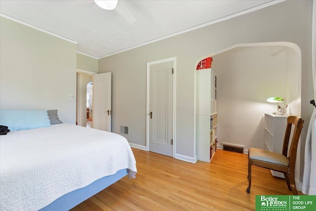 bedroom with light wood-style floors, crown molding, and baseboards