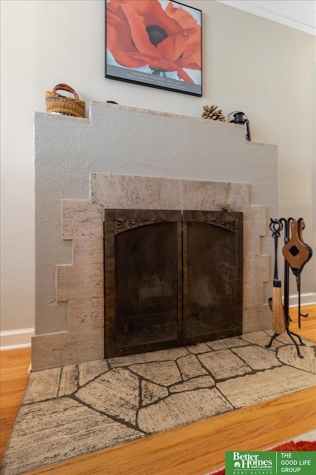detailed view of wood finished floors, baseboards, and crown molding
