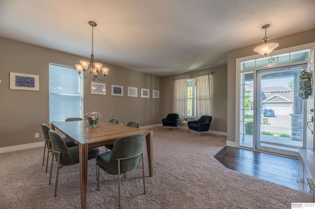 dining space with carpet floors, a chandelier, and baseboards