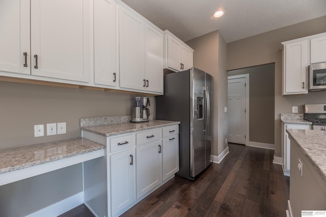 kitchen featuring stainless steel appliances, white cabinetry, dark wood finished floors, light stone countertops, and recessed lighting
