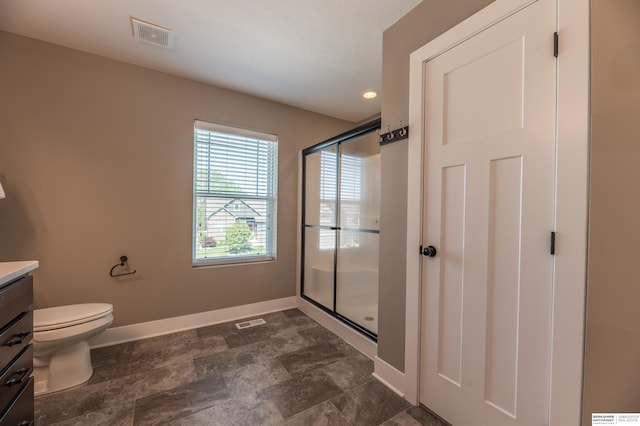 bathroom with vanity, baseboards, a shower stall, and toilet