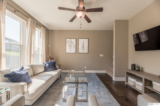 living room with dark wood-style floors, ceiling fan, and baseboards