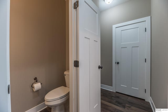 bathroom featuring toilet, baseboards, and wood finished floors