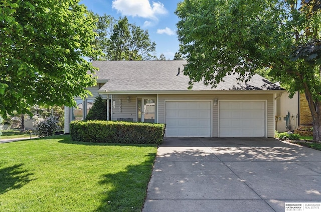 view of front of house with a front lawn, concrete driveway, an attached garage, and a shingled roof
