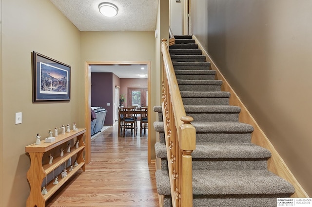 2103 John St, Papillion, NE 68133 - stairway with wood finished floors and a textured ceiling